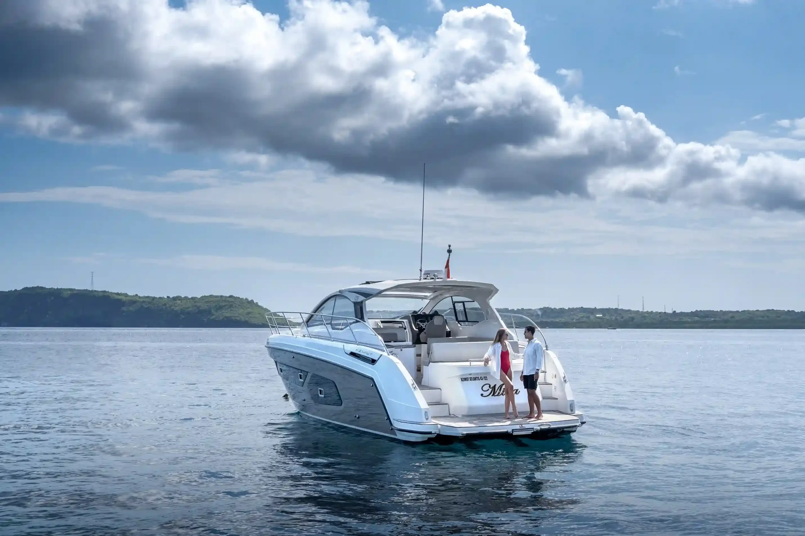A crewed motor yacht under way with guests on the aft deck